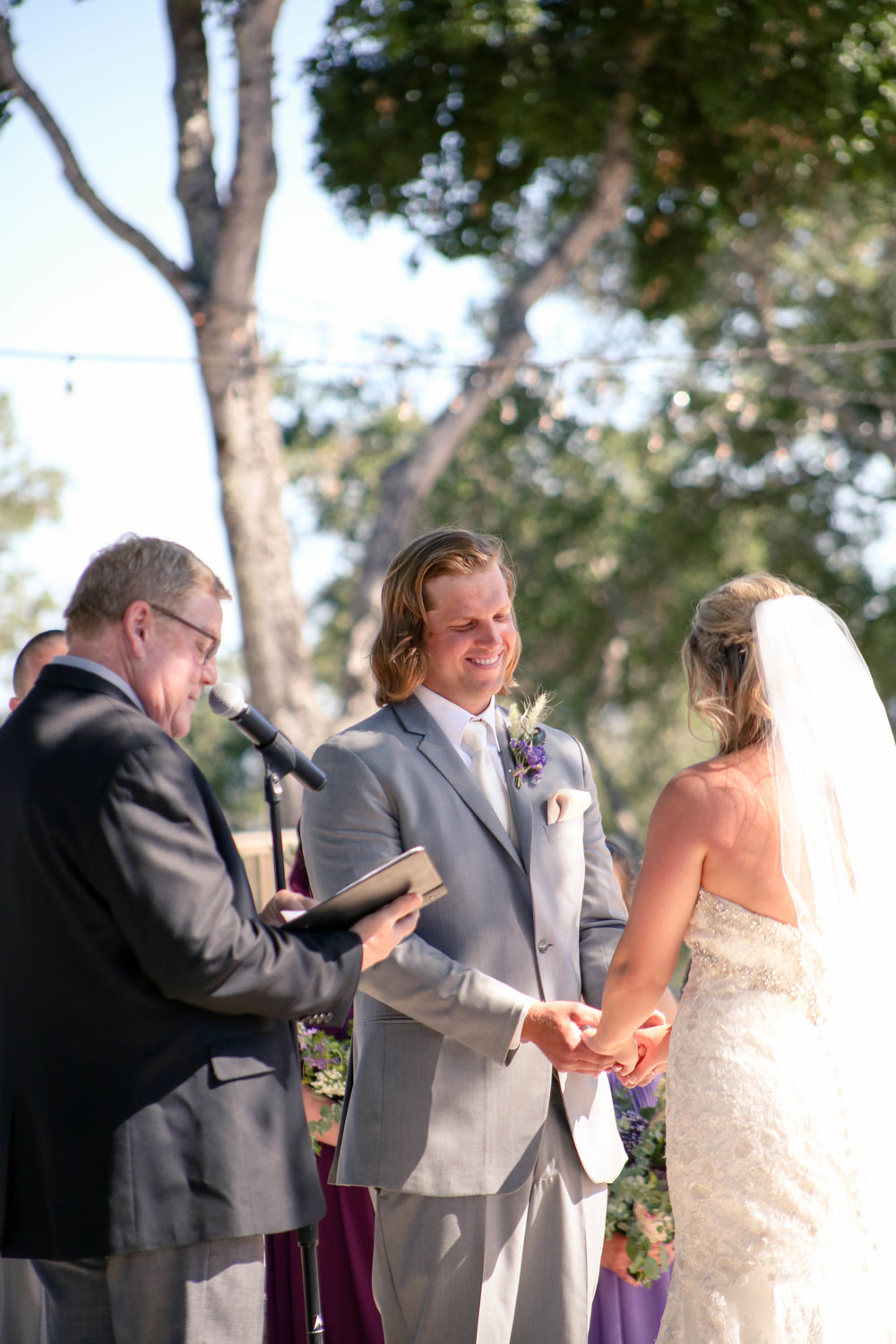 groom smiling at his bride during an outdoor wedding ceremony