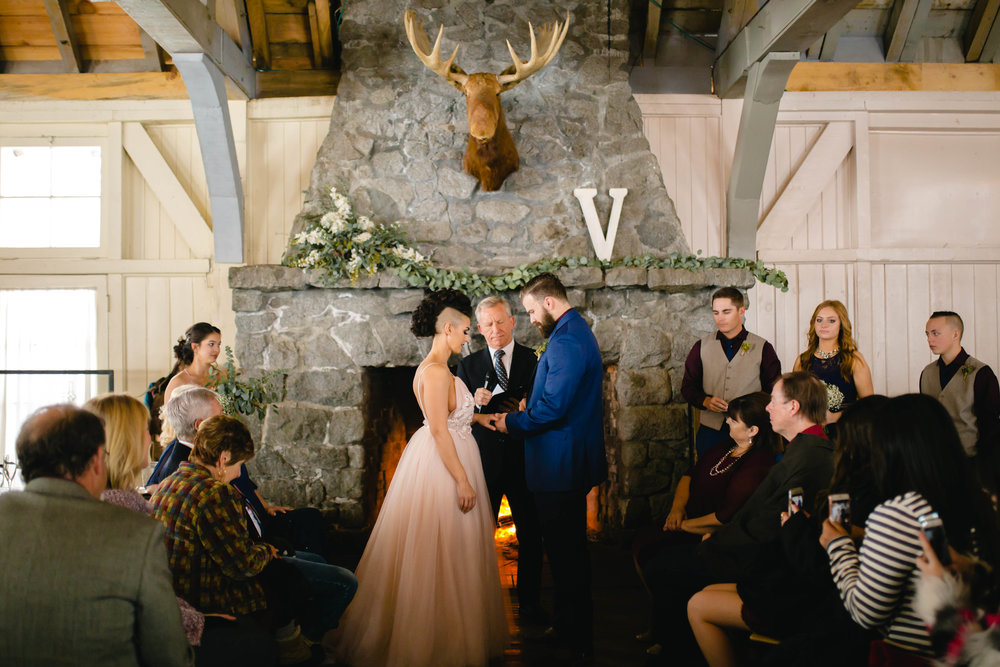 groom giving the bride her ring during a fireside wedding ceremony