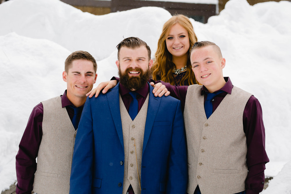 snowy wedding photos of the groom and his siblings