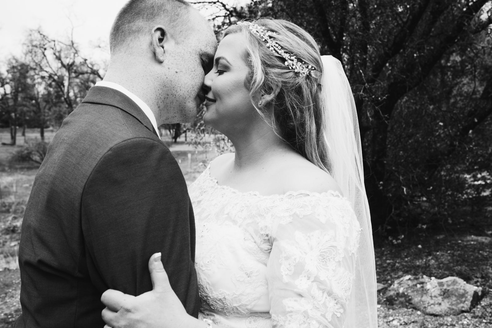 black and white photo of a bride and groom kissing