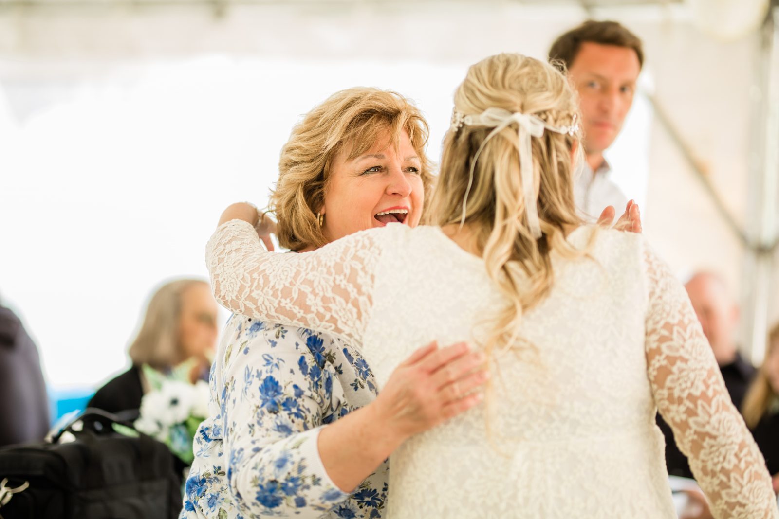 bride hugging a guest at a casual wedding ceremony