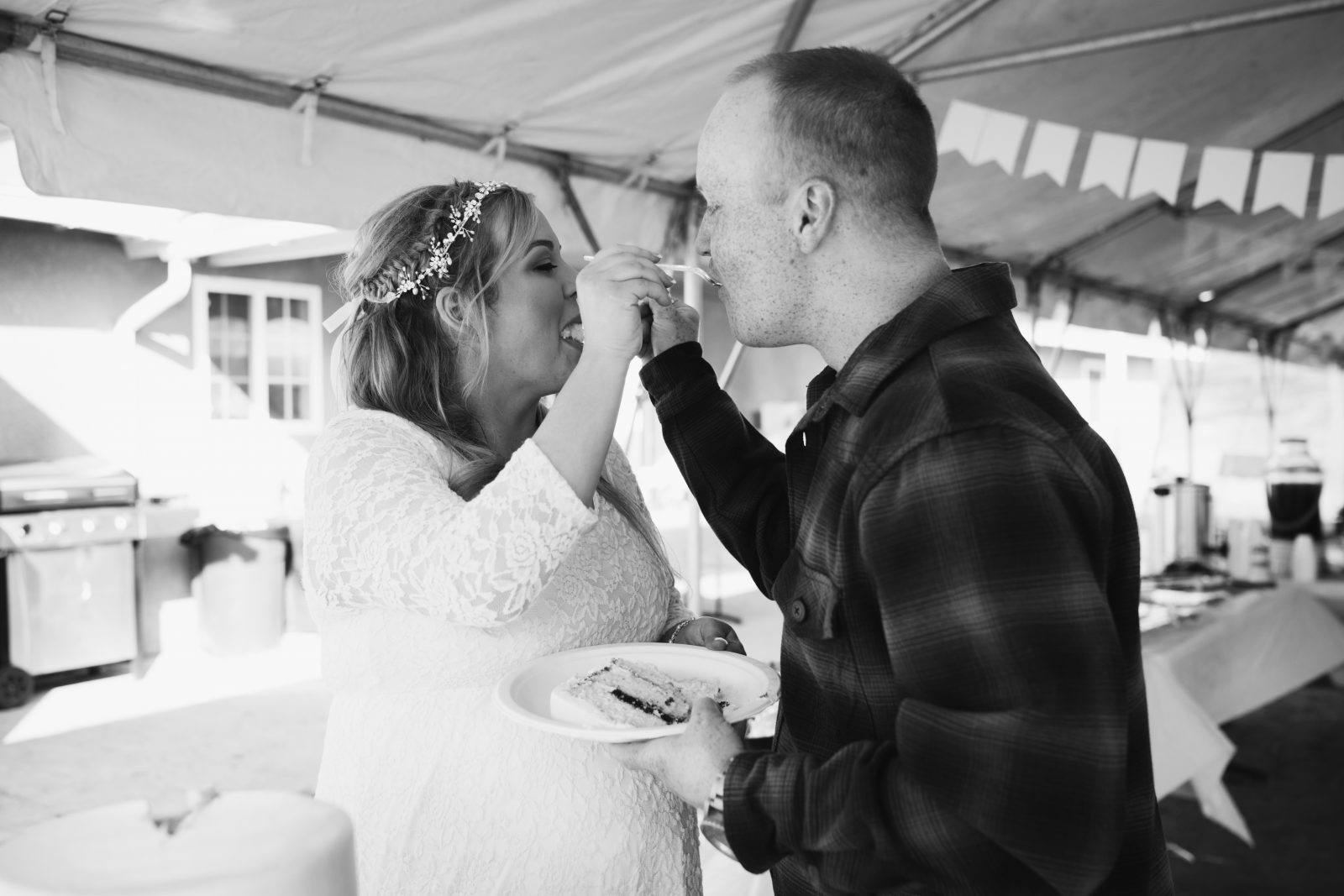 bride and groom eating wedding cake at a casual wedding ceremony