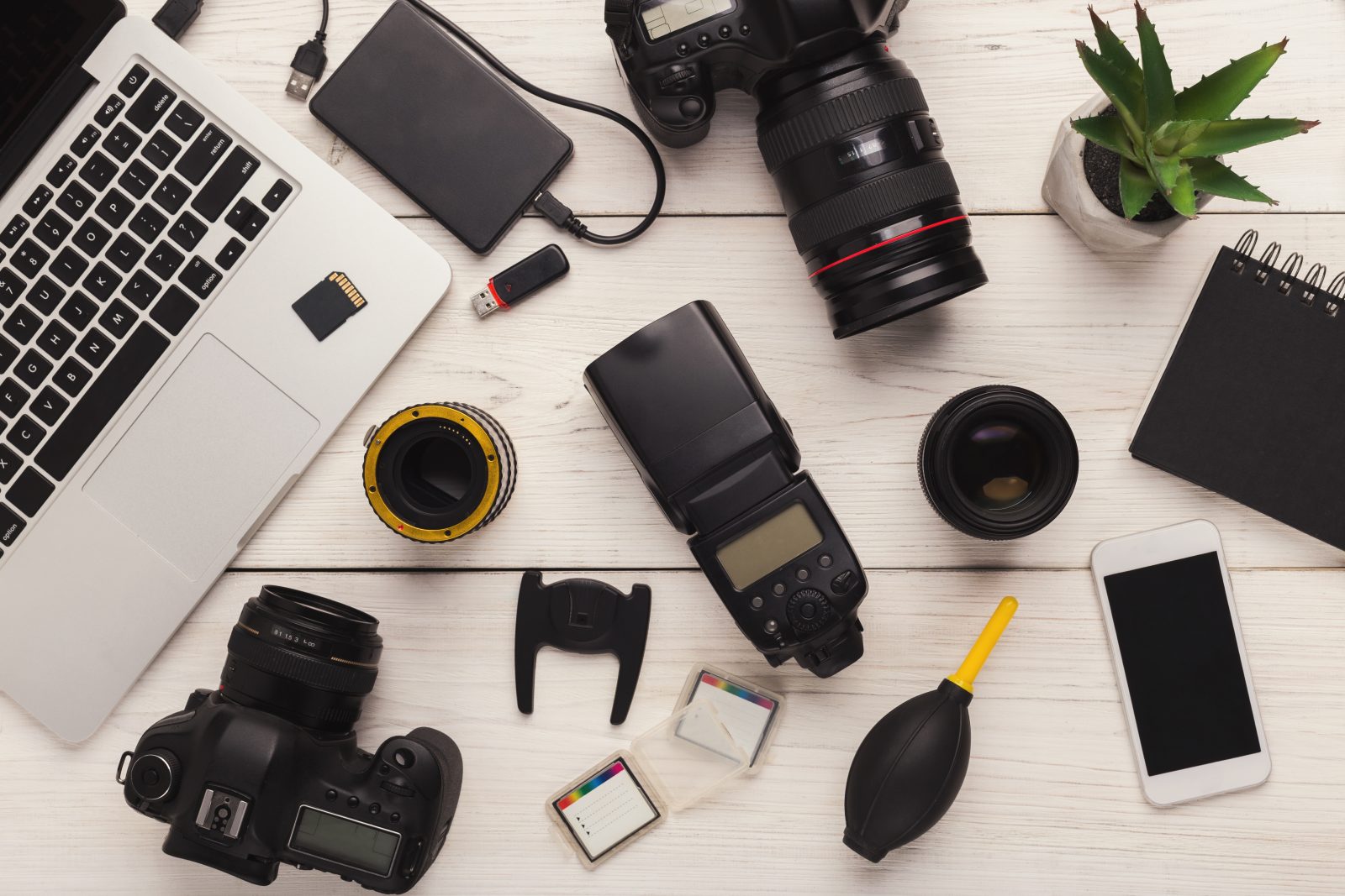memory cards, dslr cameras, macbook and photography gear lay flat photo
