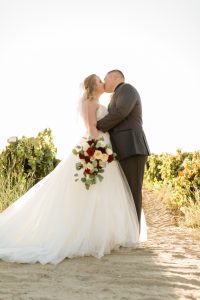 couple kissing in the vineyards at tuscan gardens venue a fresno wedding venue