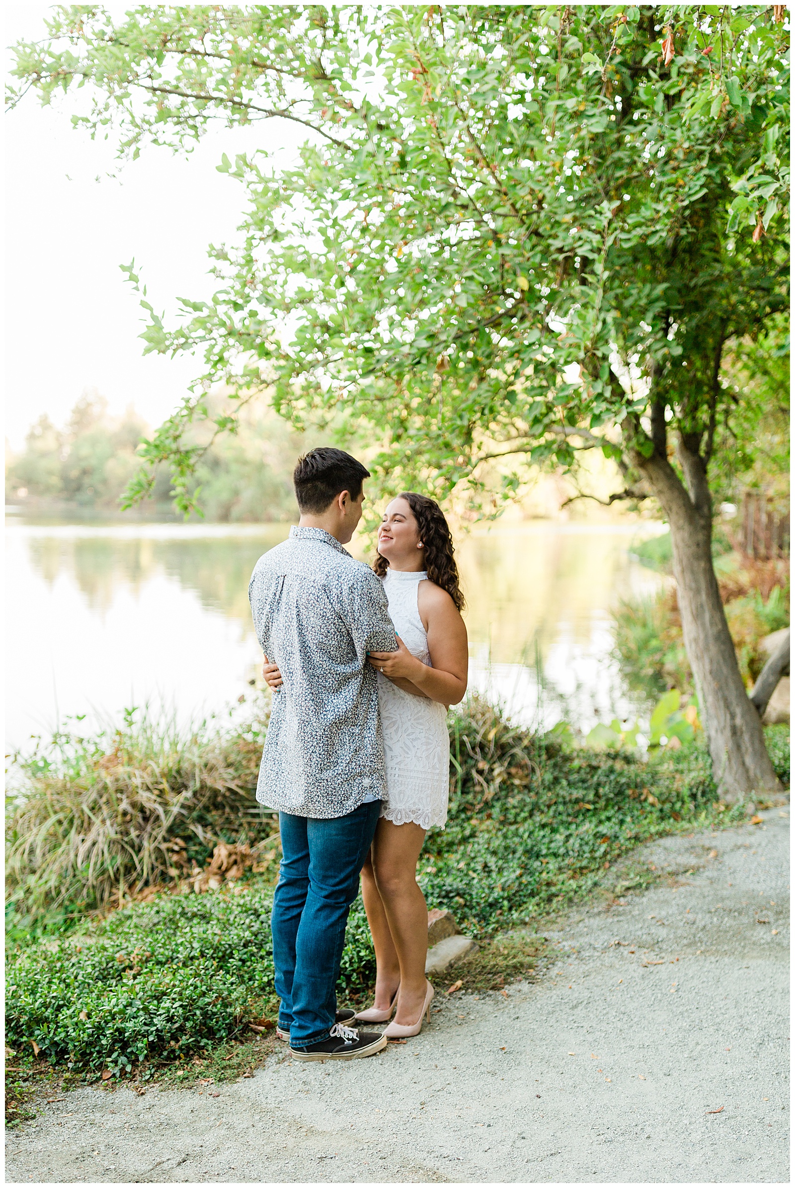 newly engaged couple embracing by a lake