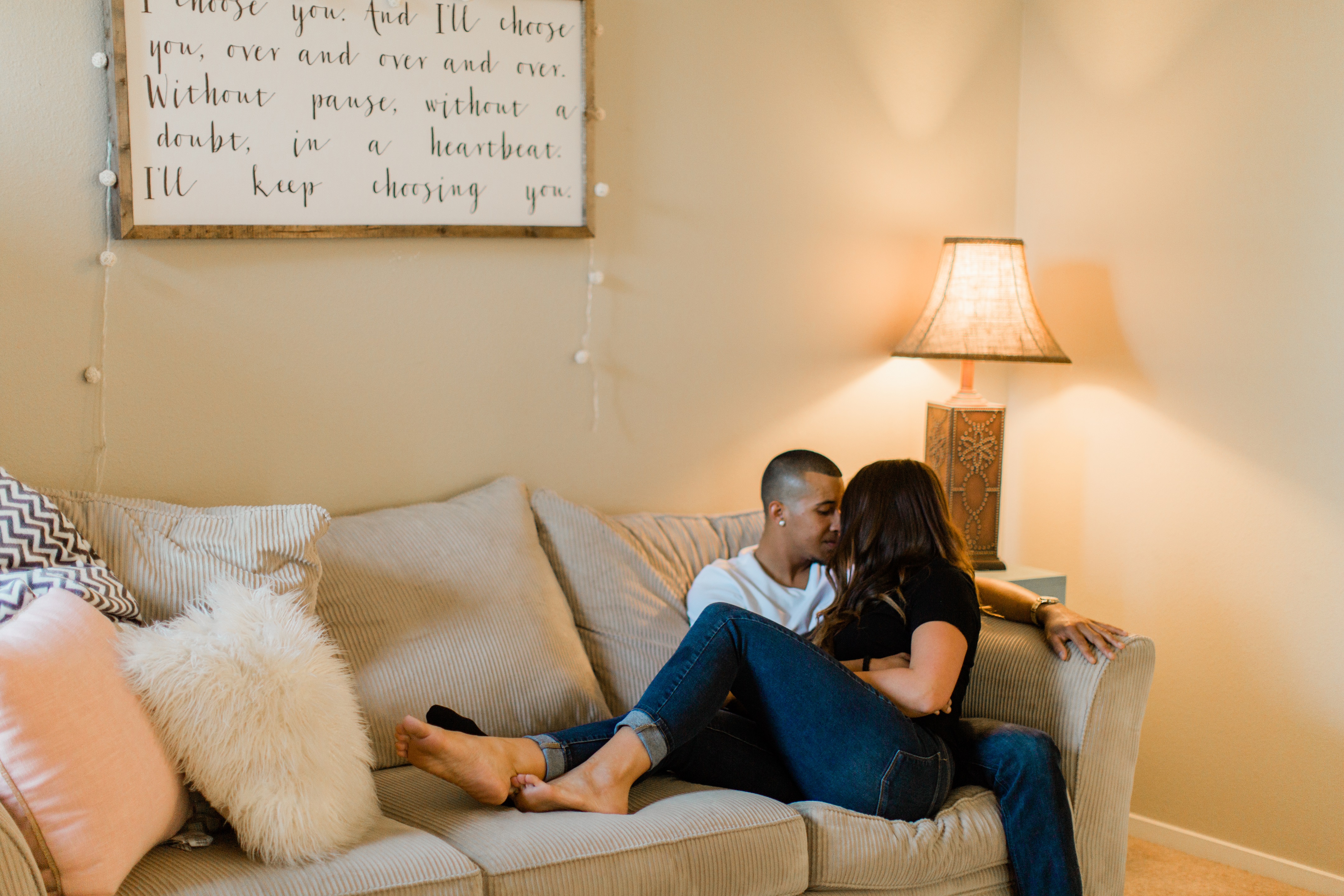 couple cuddling on the couch for an in home engagement session by megan helm photography