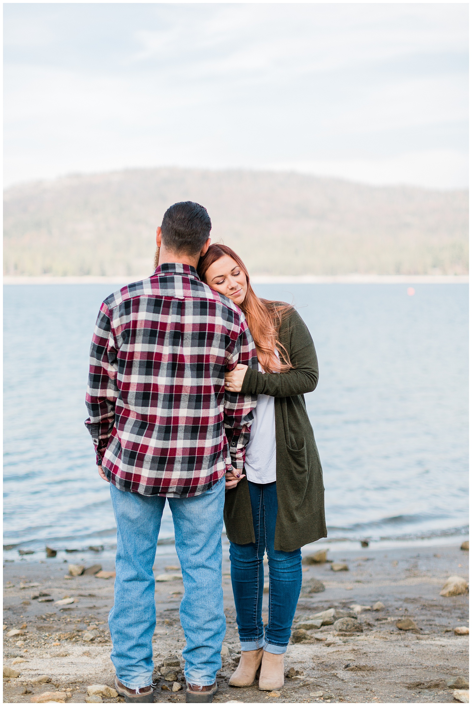 couple standing by the lake during an engagement photo shoot