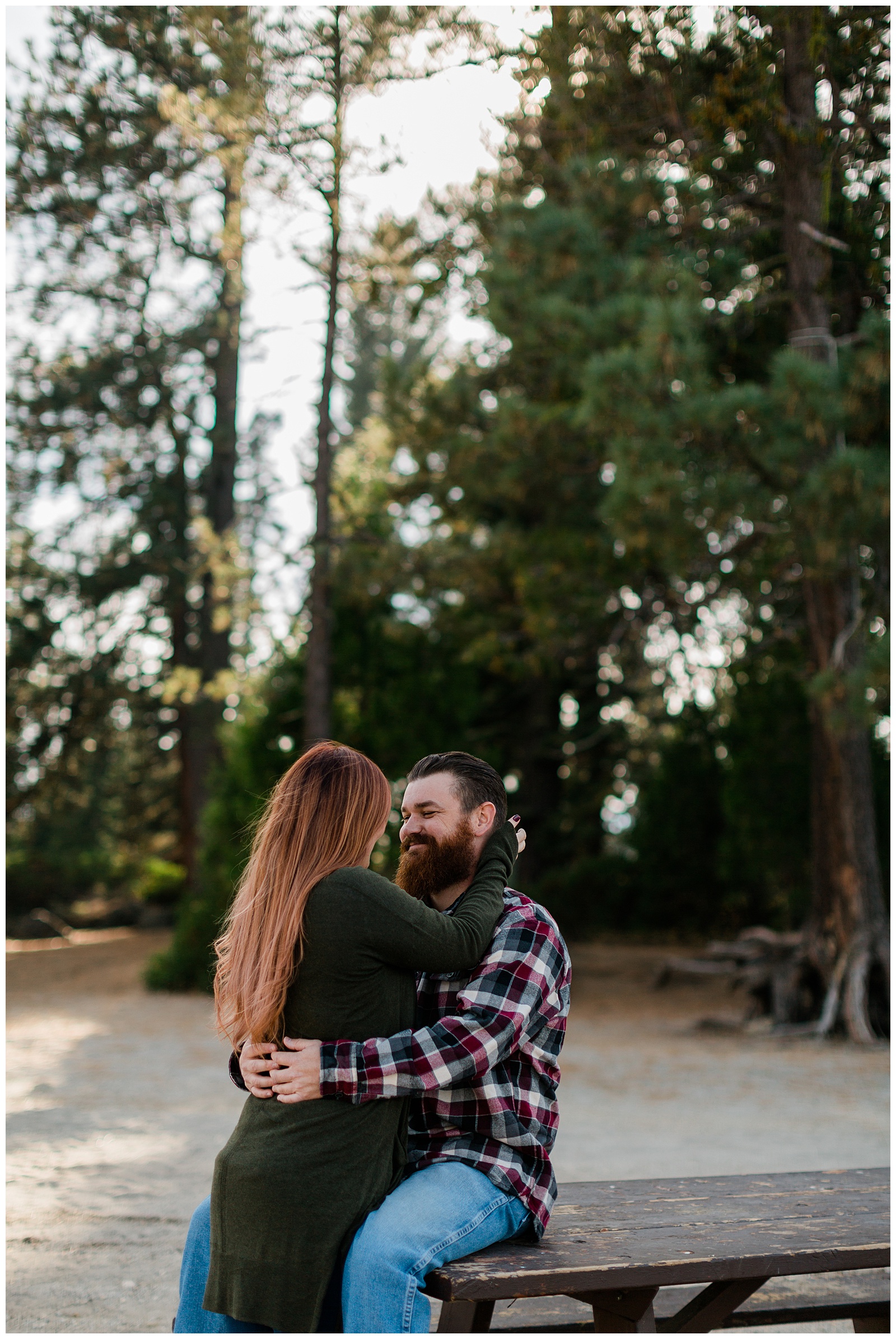 couple hugging on a picnic bench at the lake
