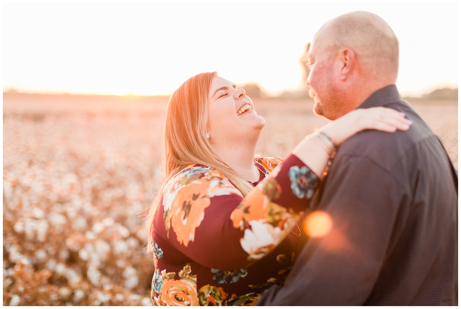 couple laughing in a cotton field during engagement photos