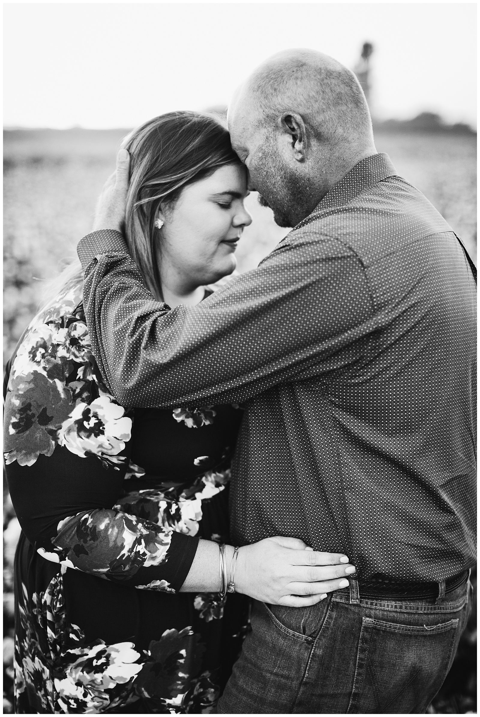 black and white photo of a couple embracing in a cotton field