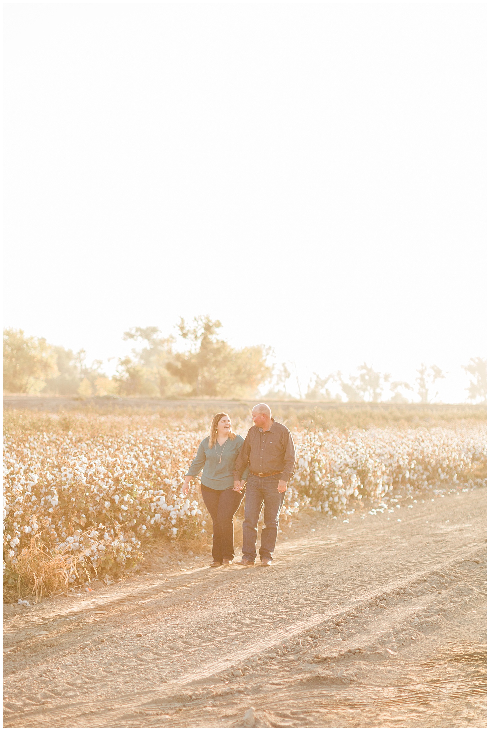 couple walking through a cotton field at sunrise