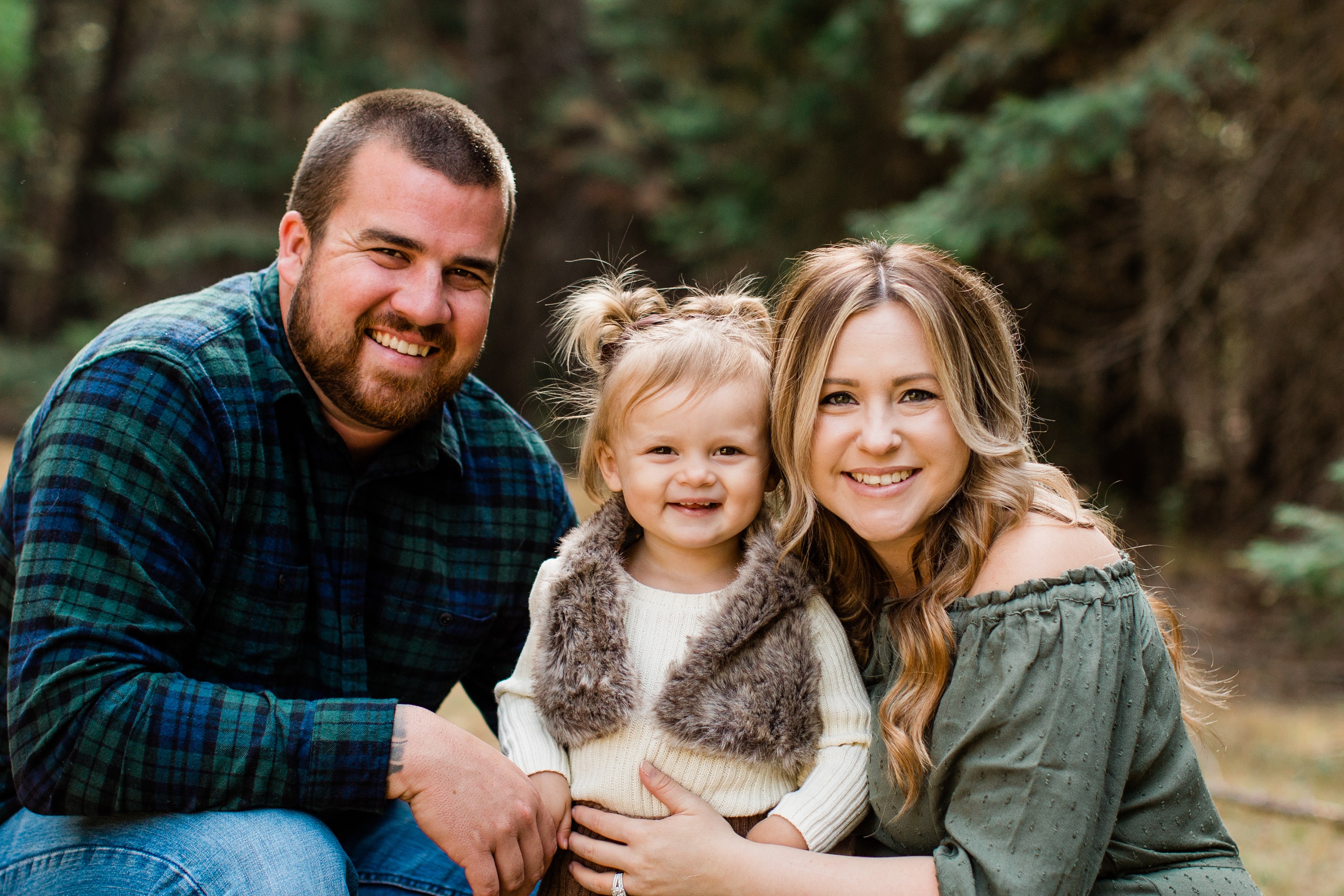 family of three smiling for fall family photos