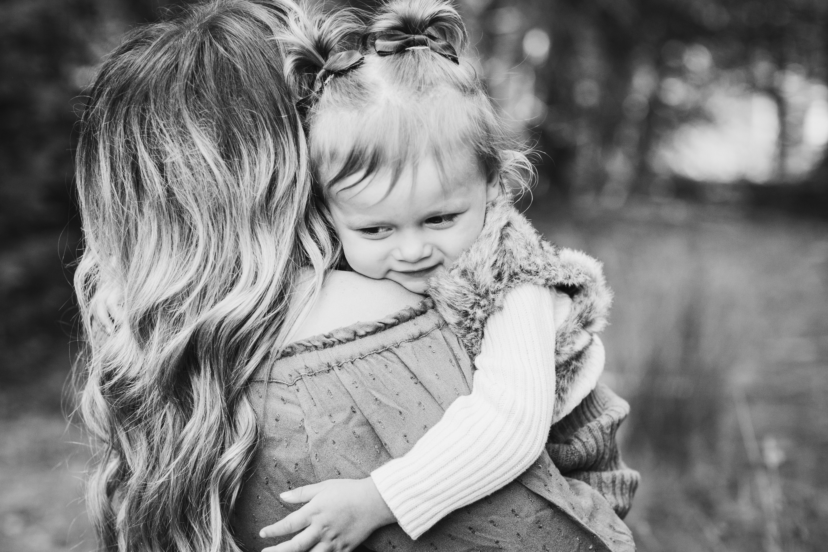 black and white photo of a little girl hugging her mom
