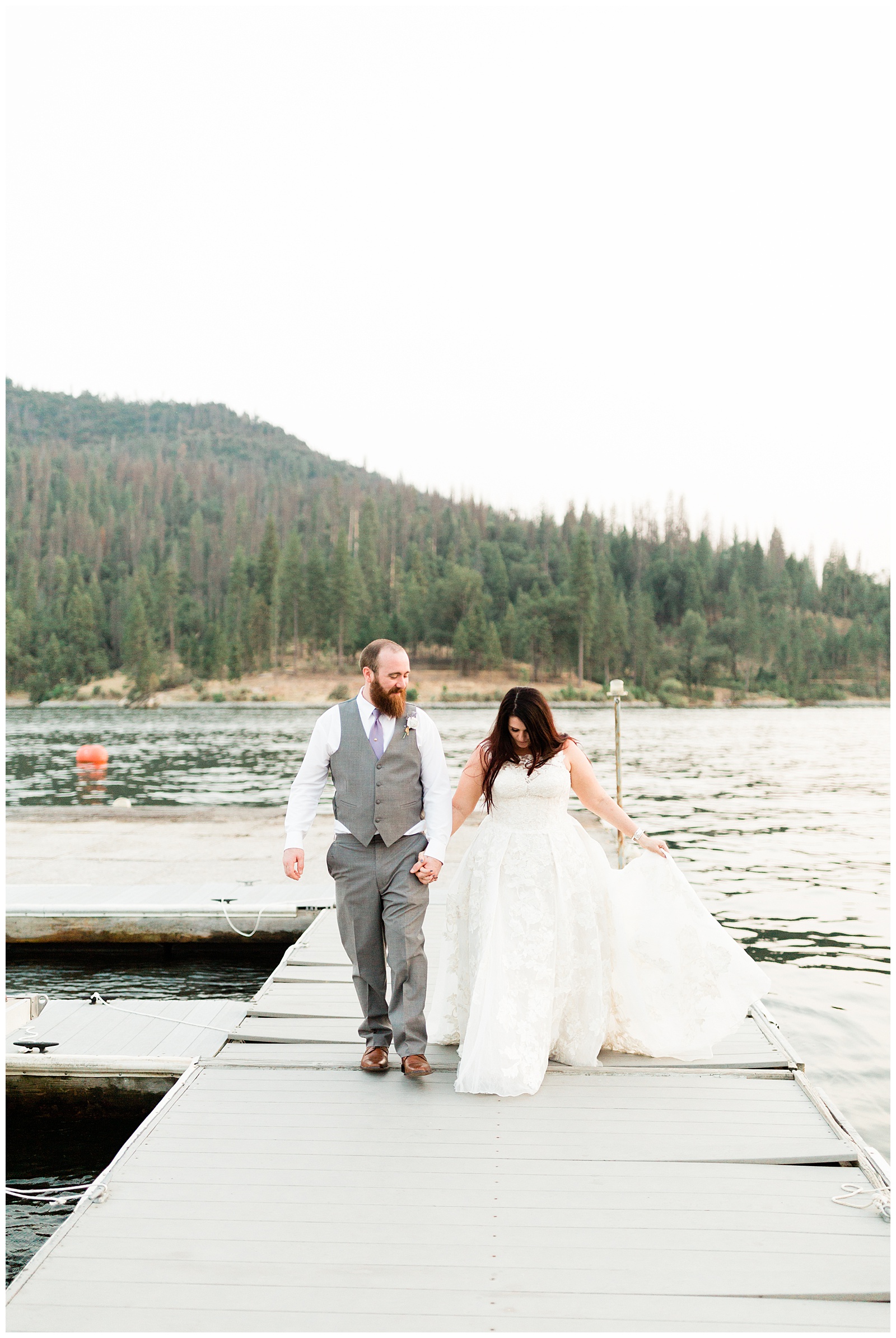 bride and groom walking along the docks taking sunset portraits on the docks at the pines resort in bass lake