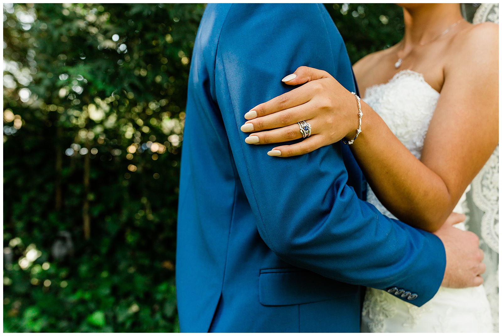 bride and groom embracing and showing off a unique sapphire wedding ring