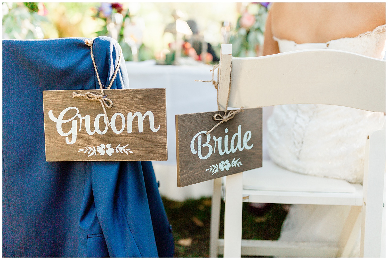 wooden bride and groom signs on the back of their chairs