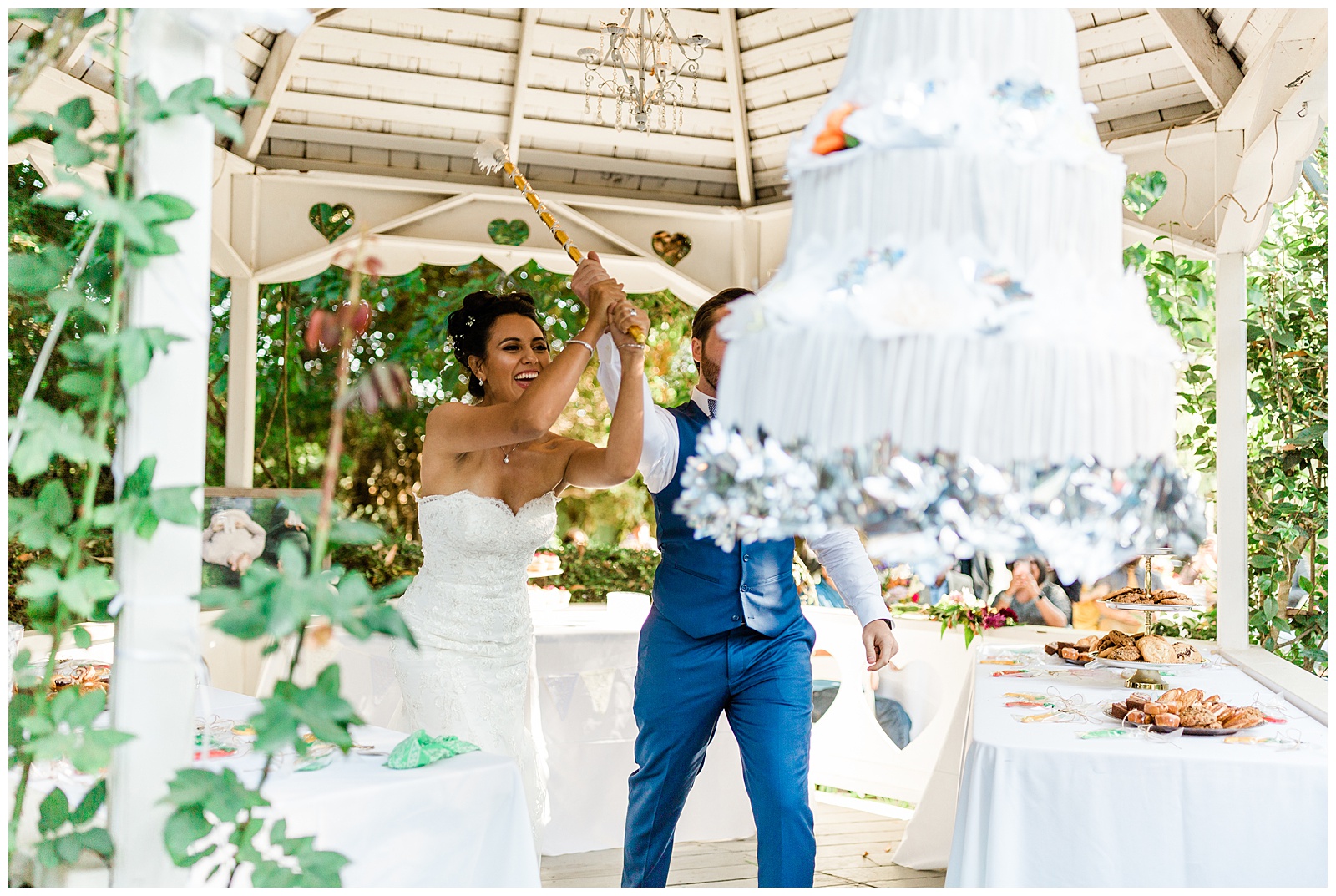 bride and groom hitting the pinata cake