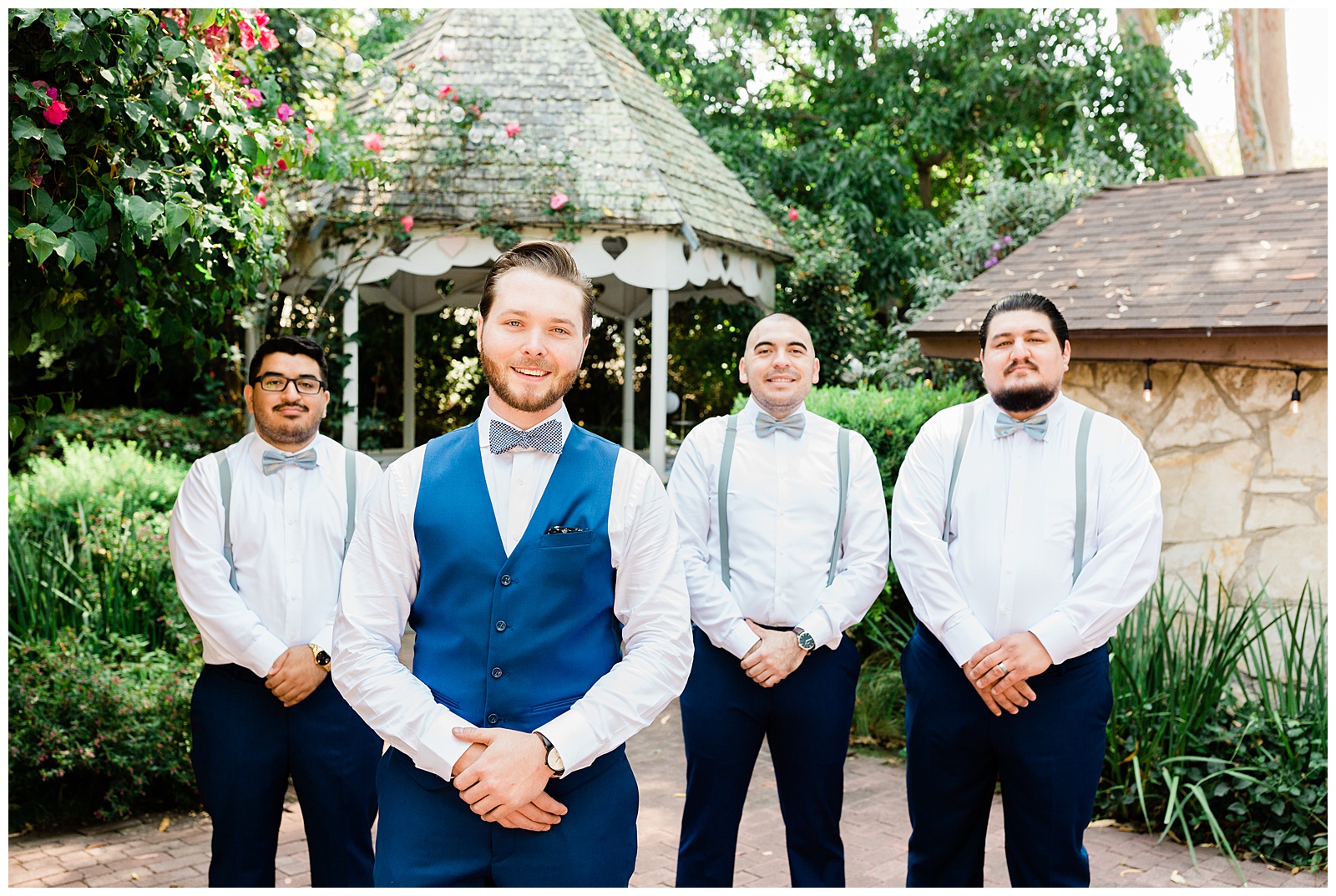 groom and his groomsmen posing for a photo at a summer garden wedding