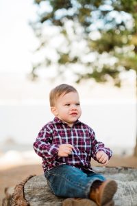 baby boy sitting on a rock during a fall family photo session at shaver lake