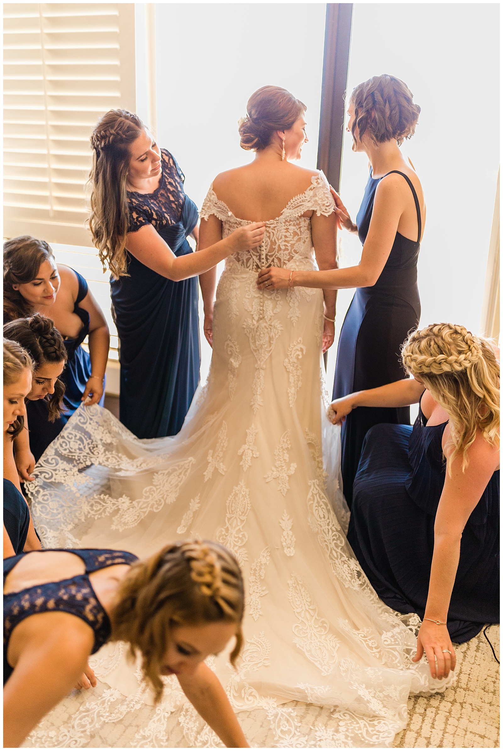 bridesmaids helping the bride with her wedding dress