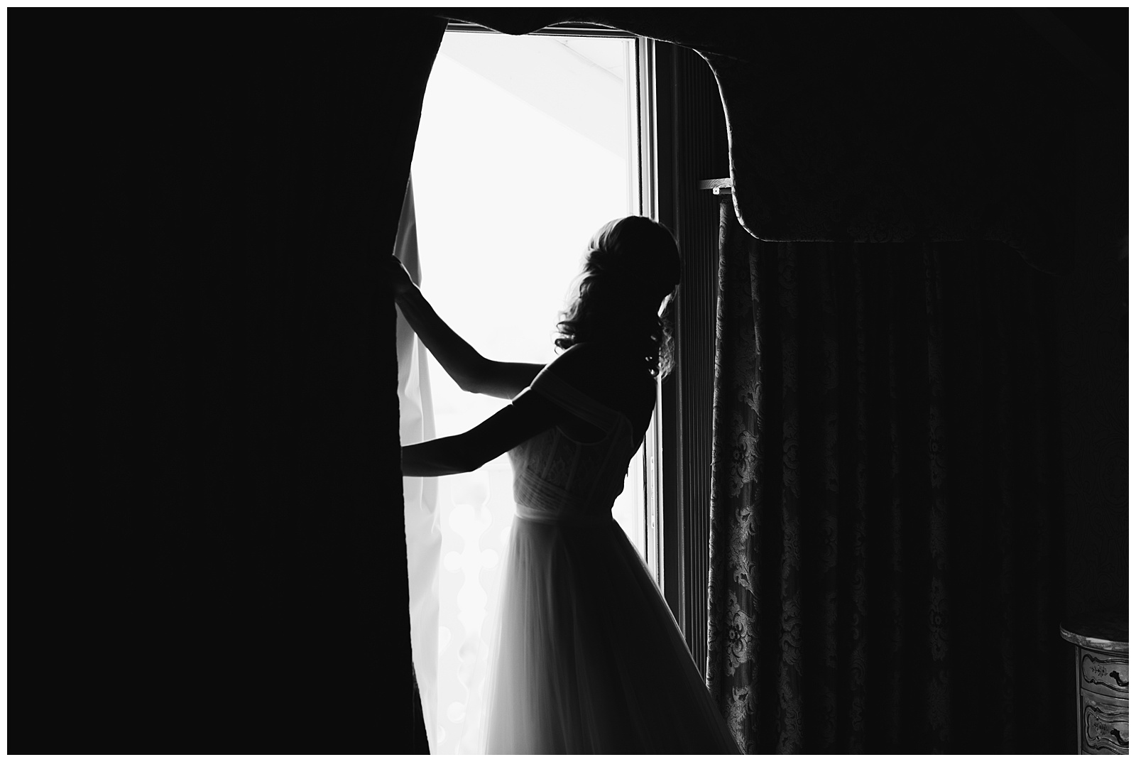 The bride opening the window to see her groom for the first time on a balcony