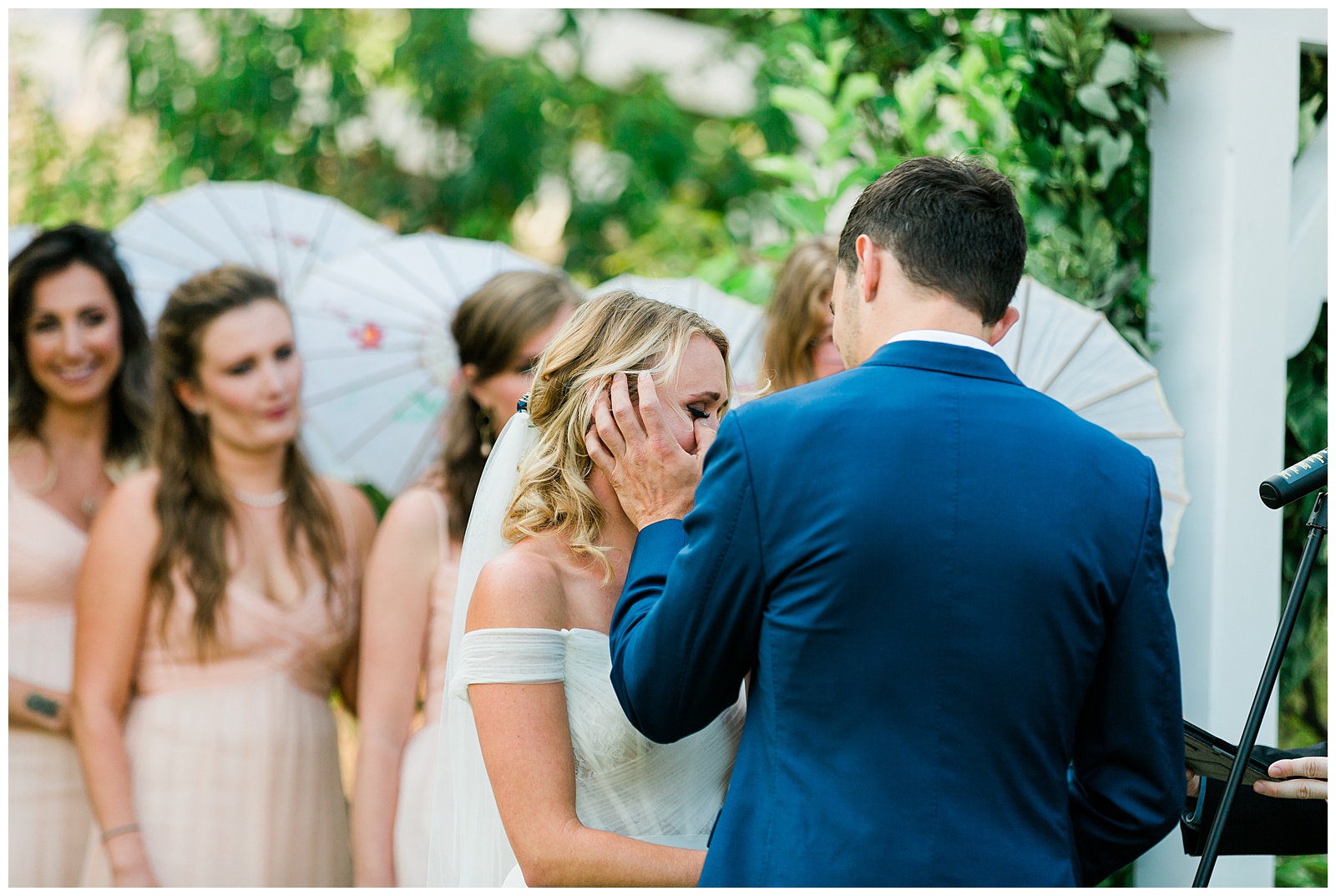 A groom wiping away his Bride's tears during their wedding ceremony