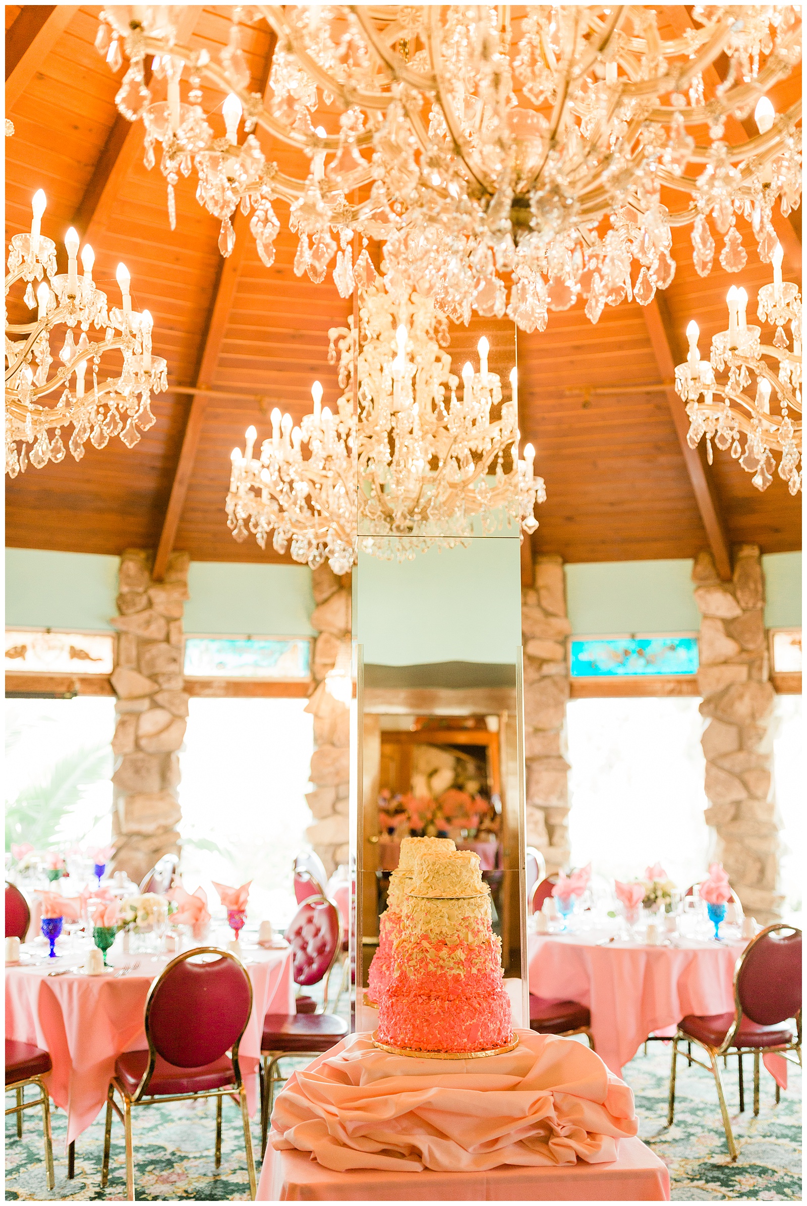Madonna Inn wedding cake underneath grand chandeliers in the Garden Room