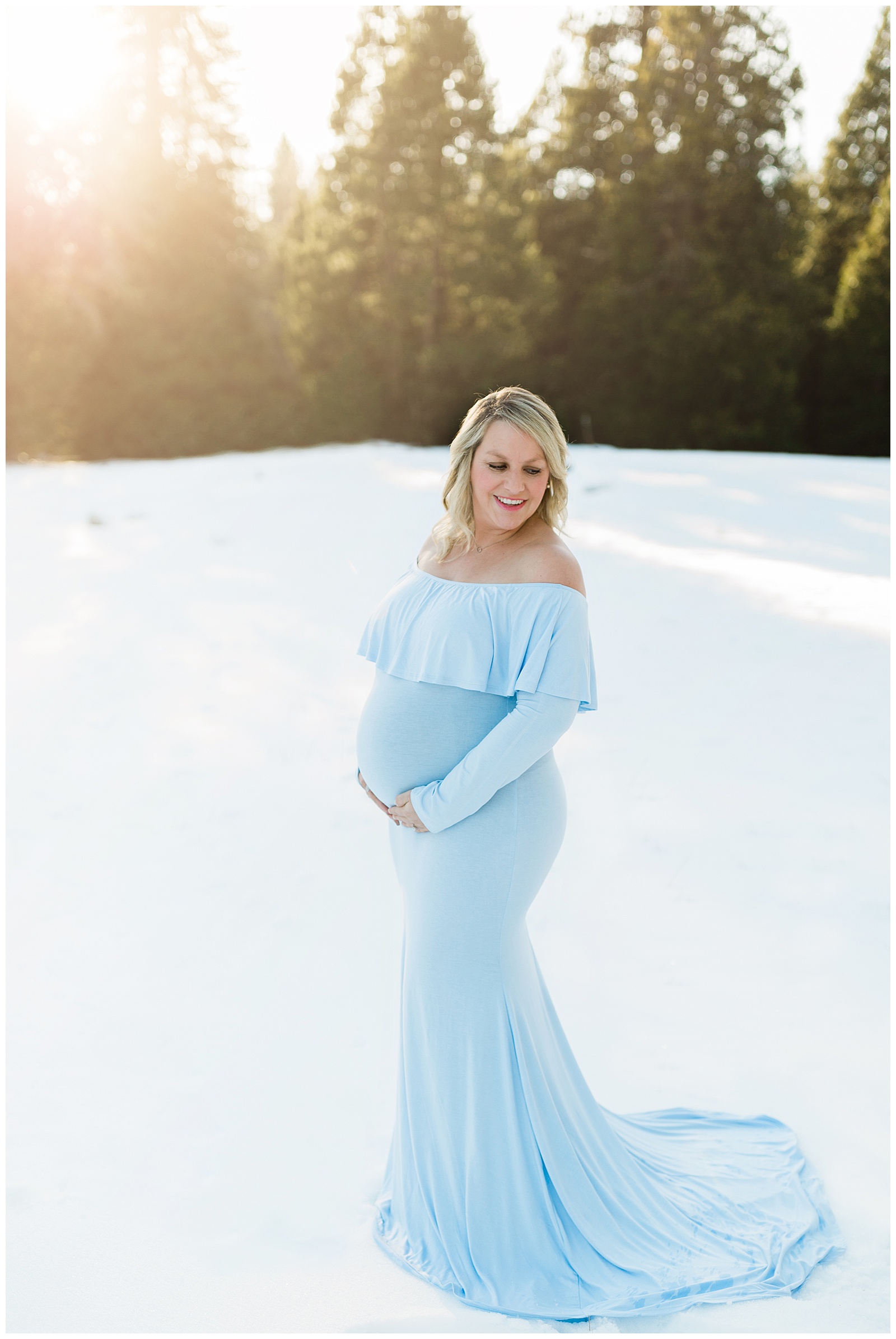 expecting mother posing in the snow for winter maternity photos