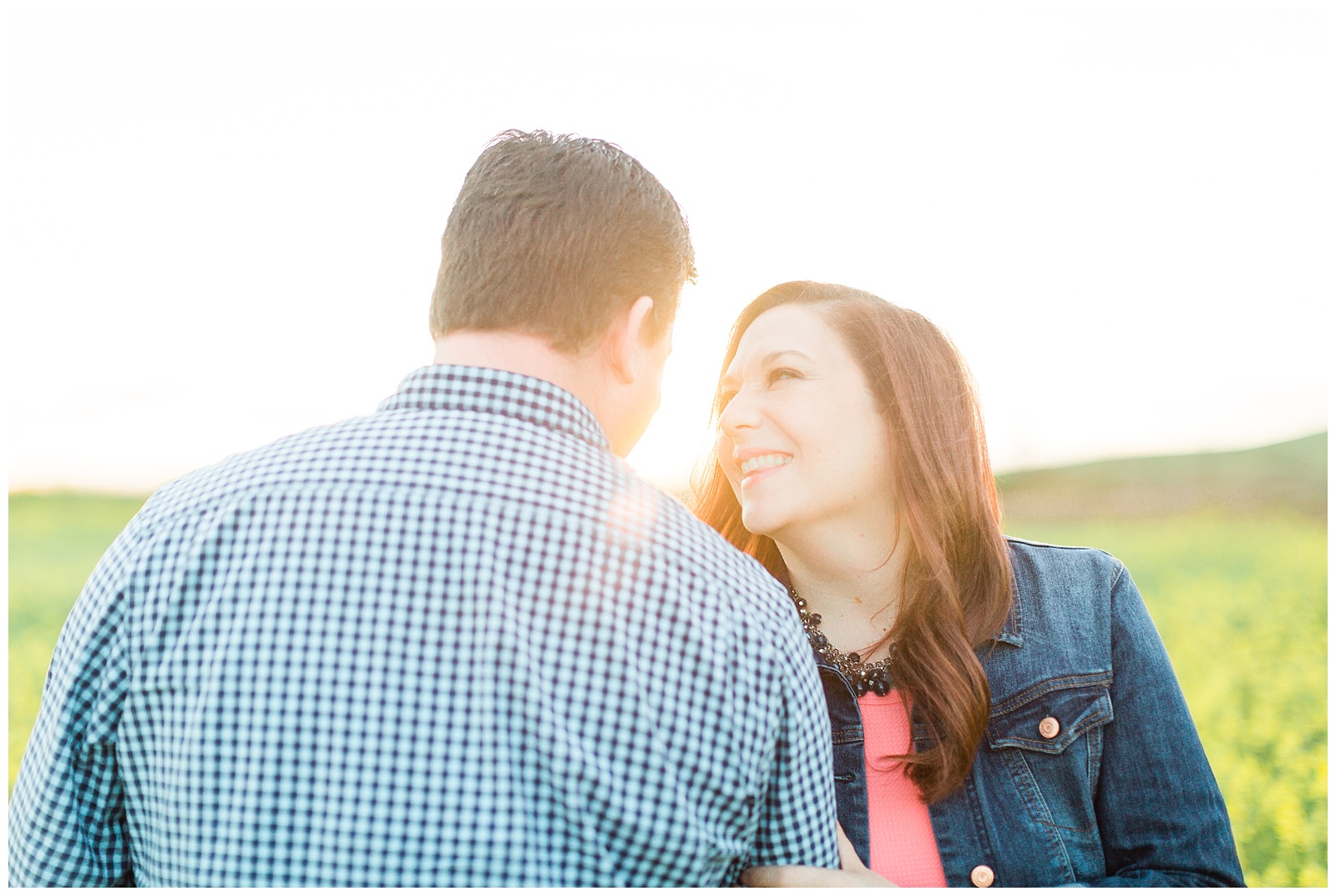 couple smiling and laughing with a sun flare