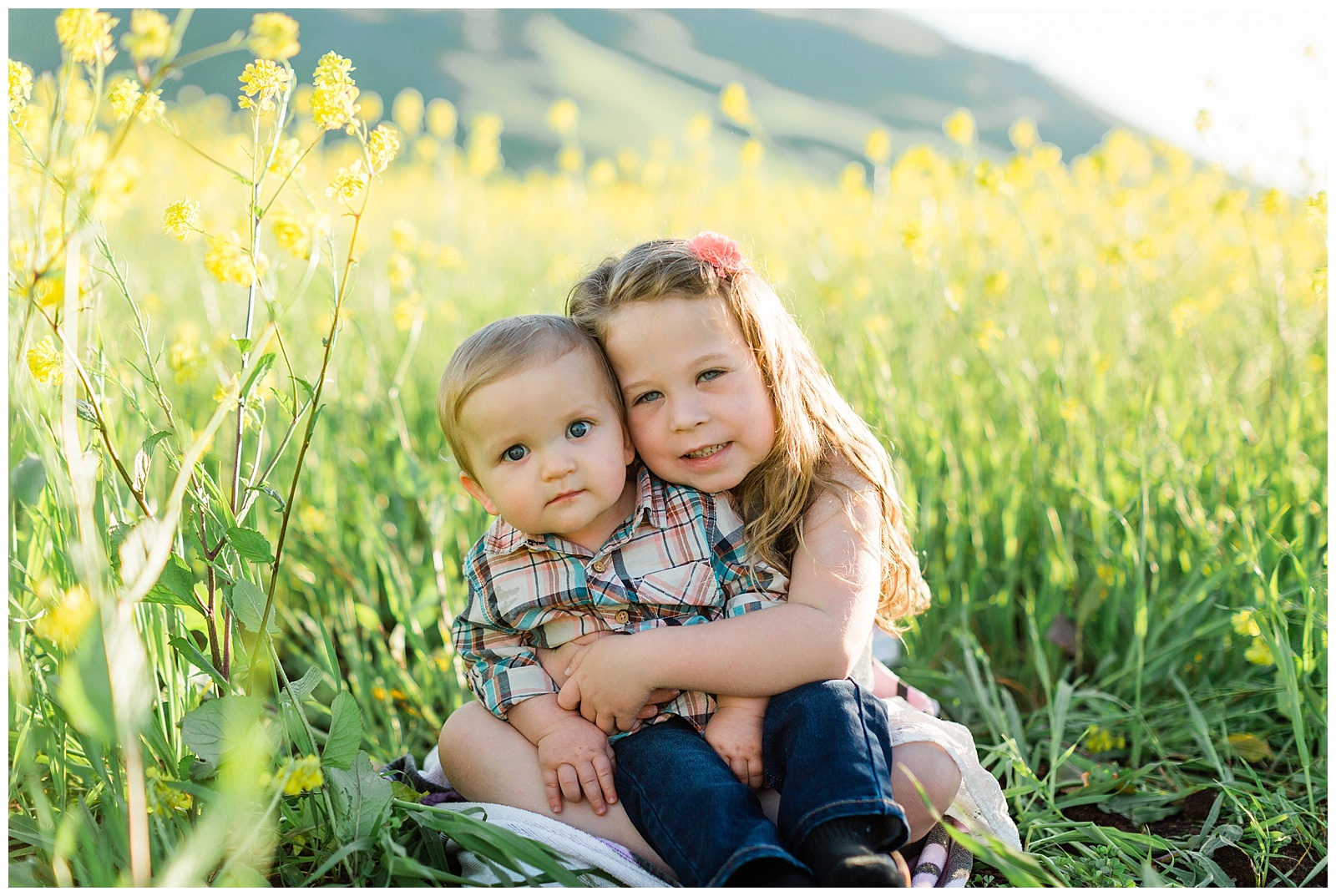 young siblings hugging in the yellow wildflowers in fresno california
