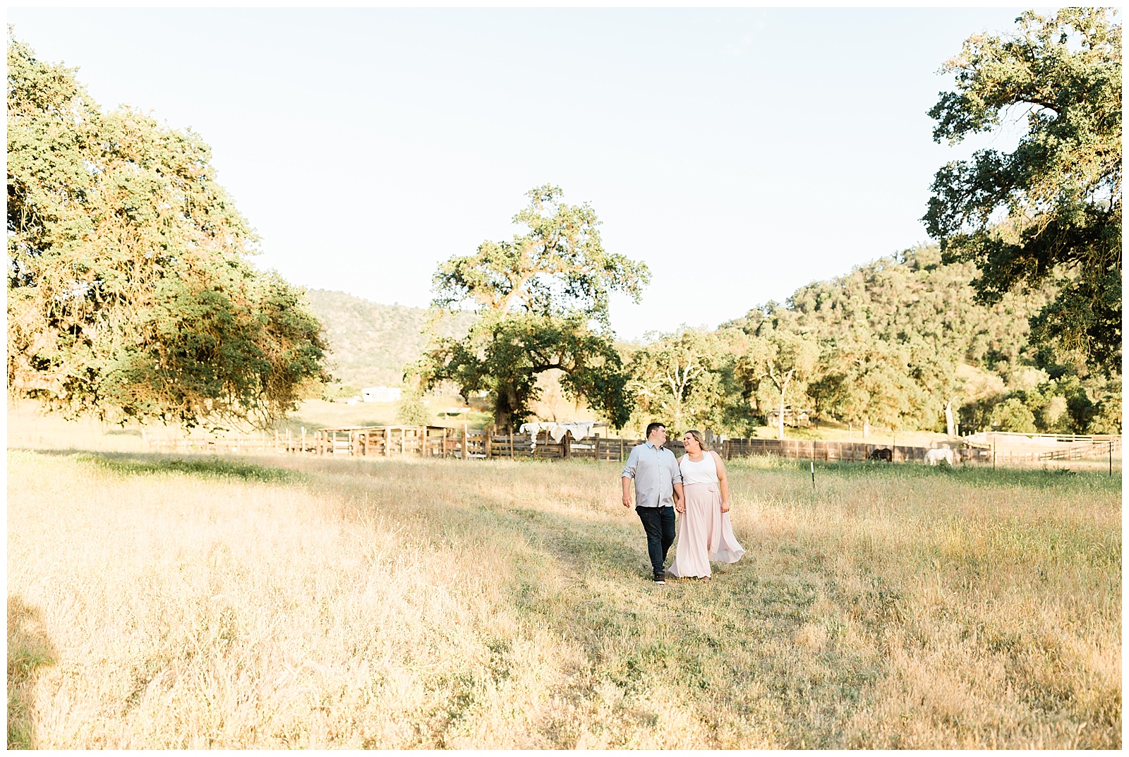 engaged couple walking and holding hands in the foothills of california