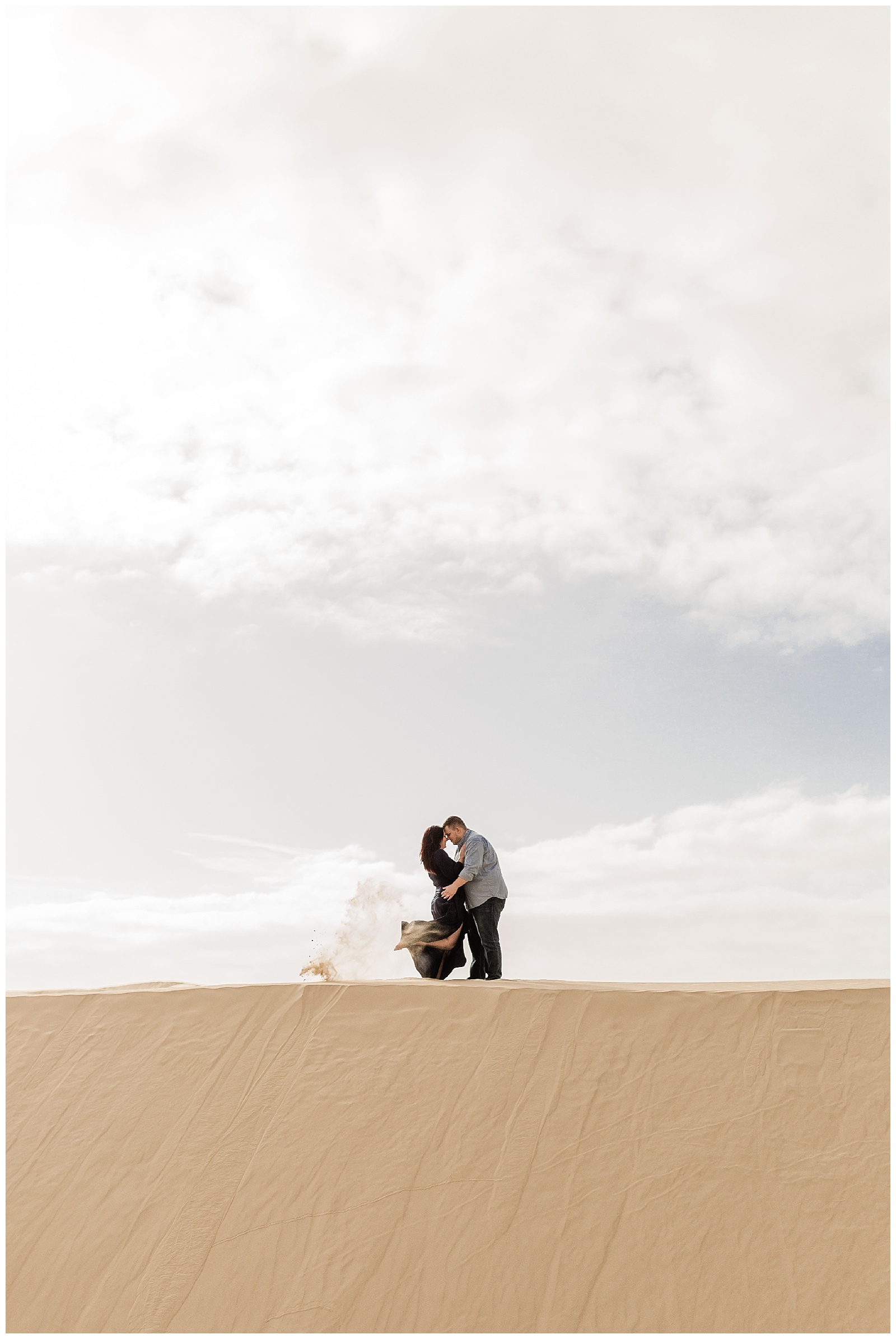 epic engagement photo of a couple embracing in the golden beach sand