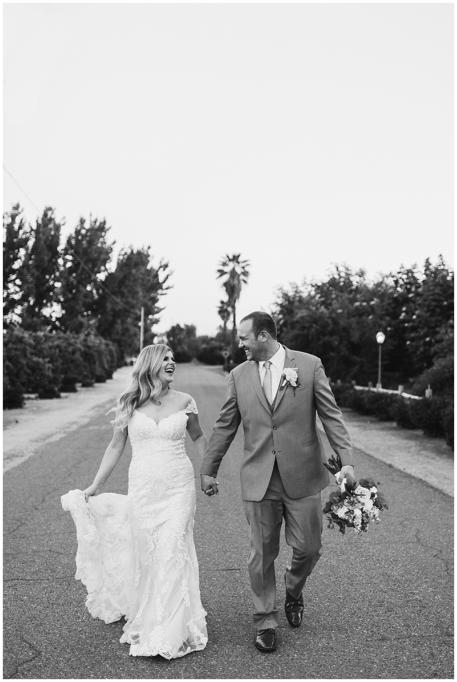 black and white photo of the bride and groom running down the street together