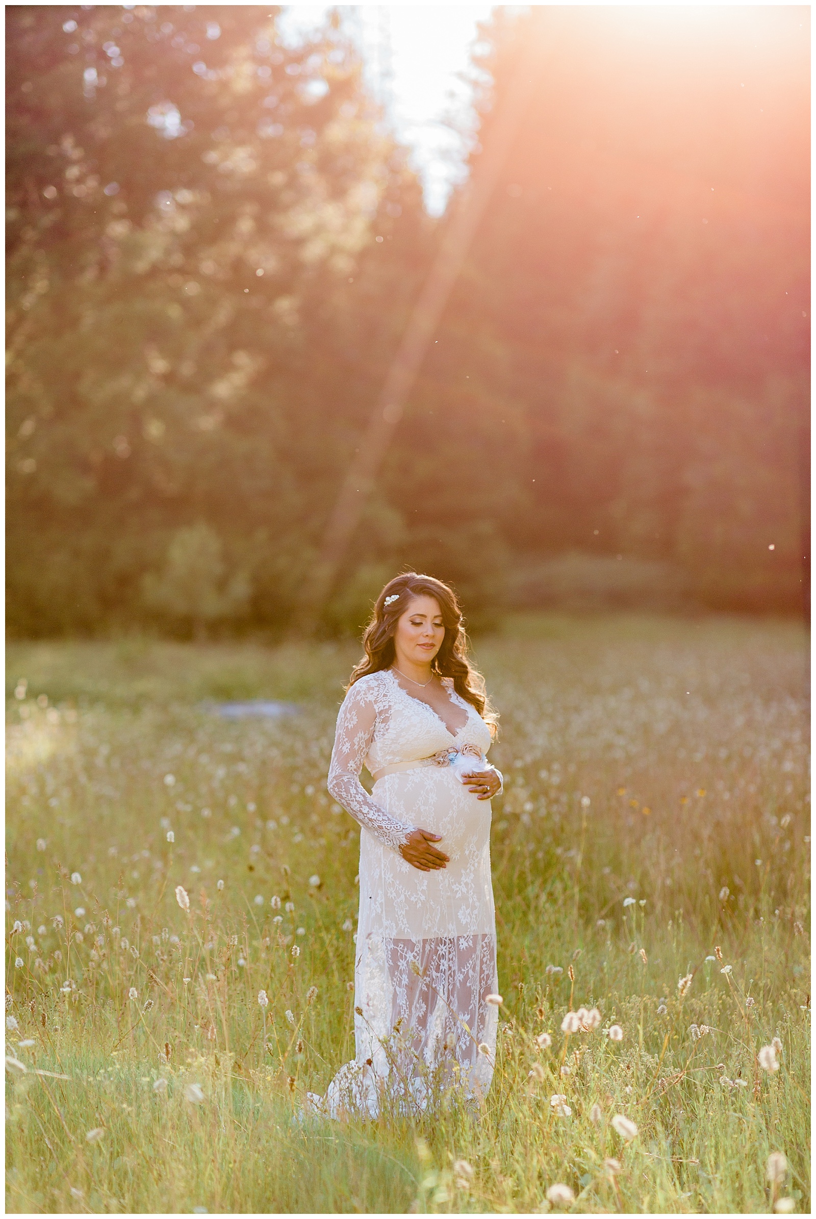 pregnant mom wearing a white lace maternity dress in a meadow