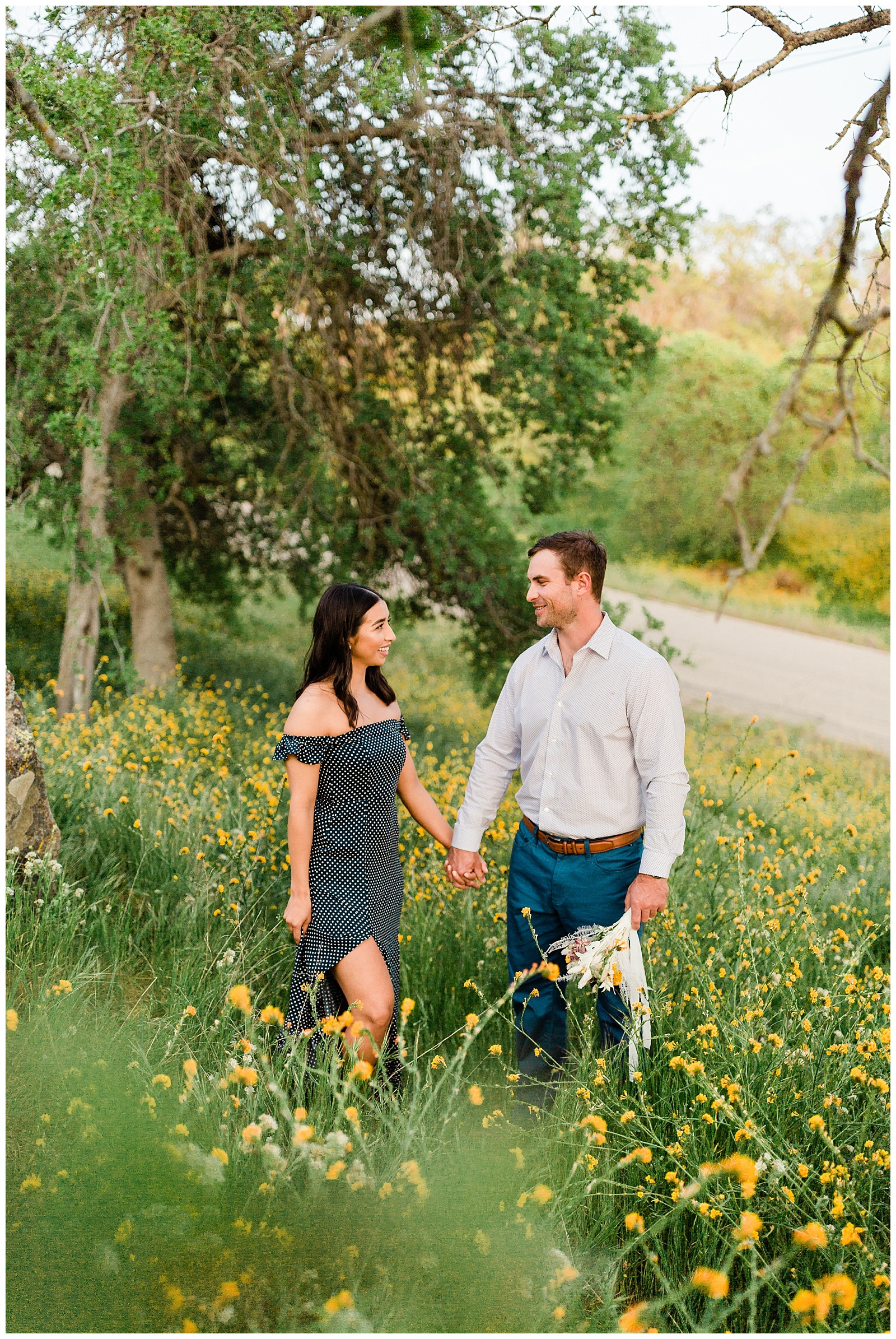 romantic photo of a couple holding hands in a wildflower field