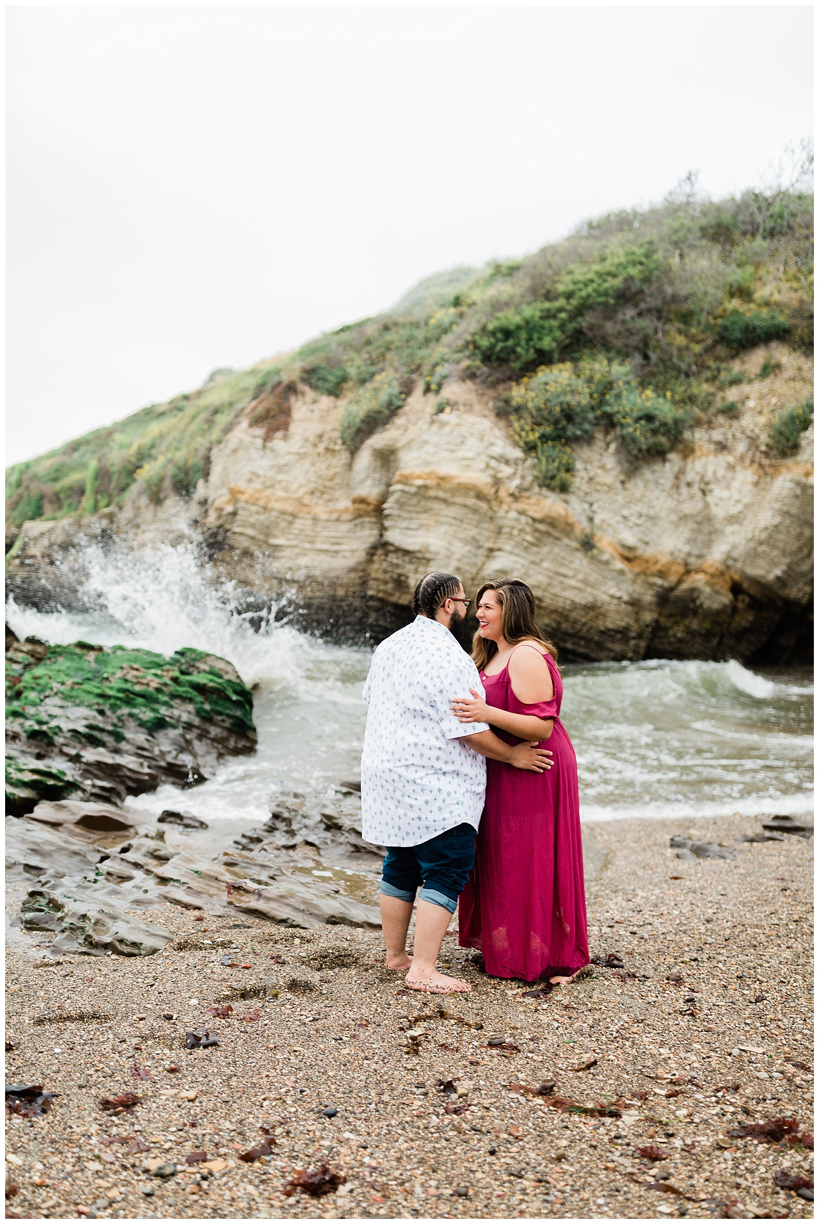 engaged couple standing near the rocky shores of montana de oro beach