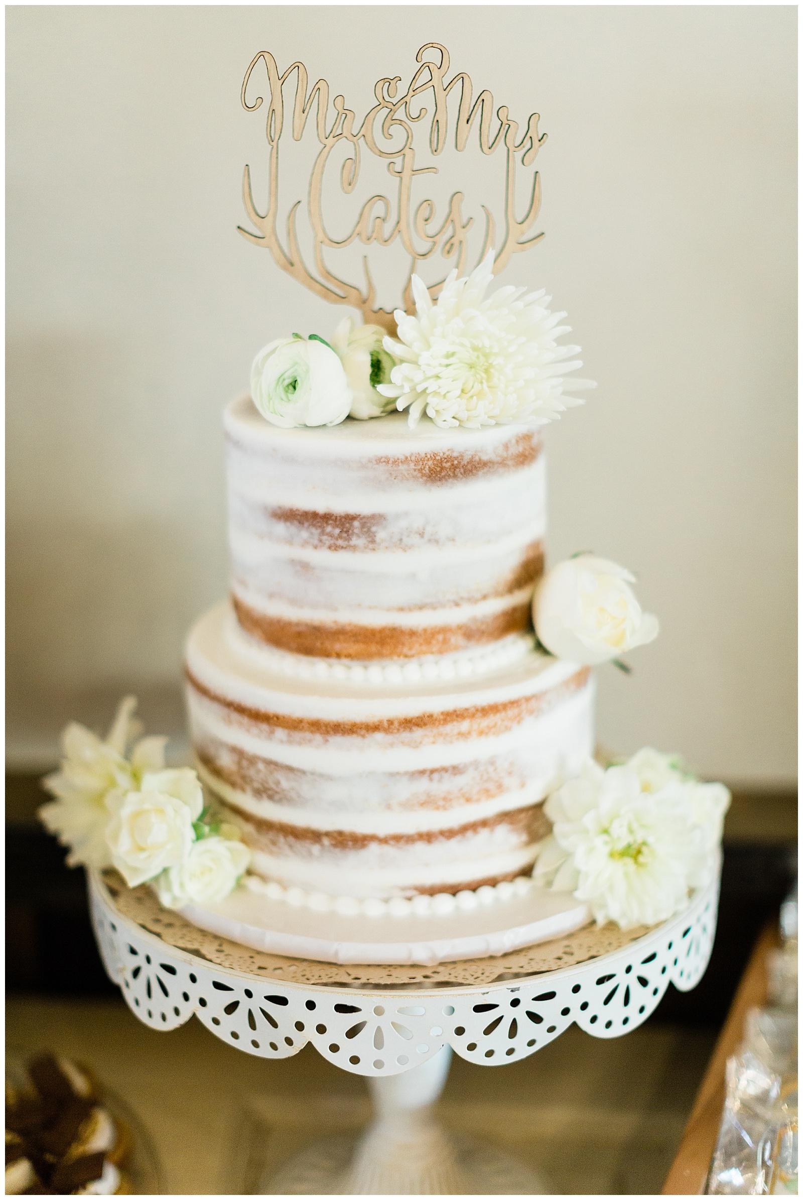 wooden cake topper on a white naked wedding cake