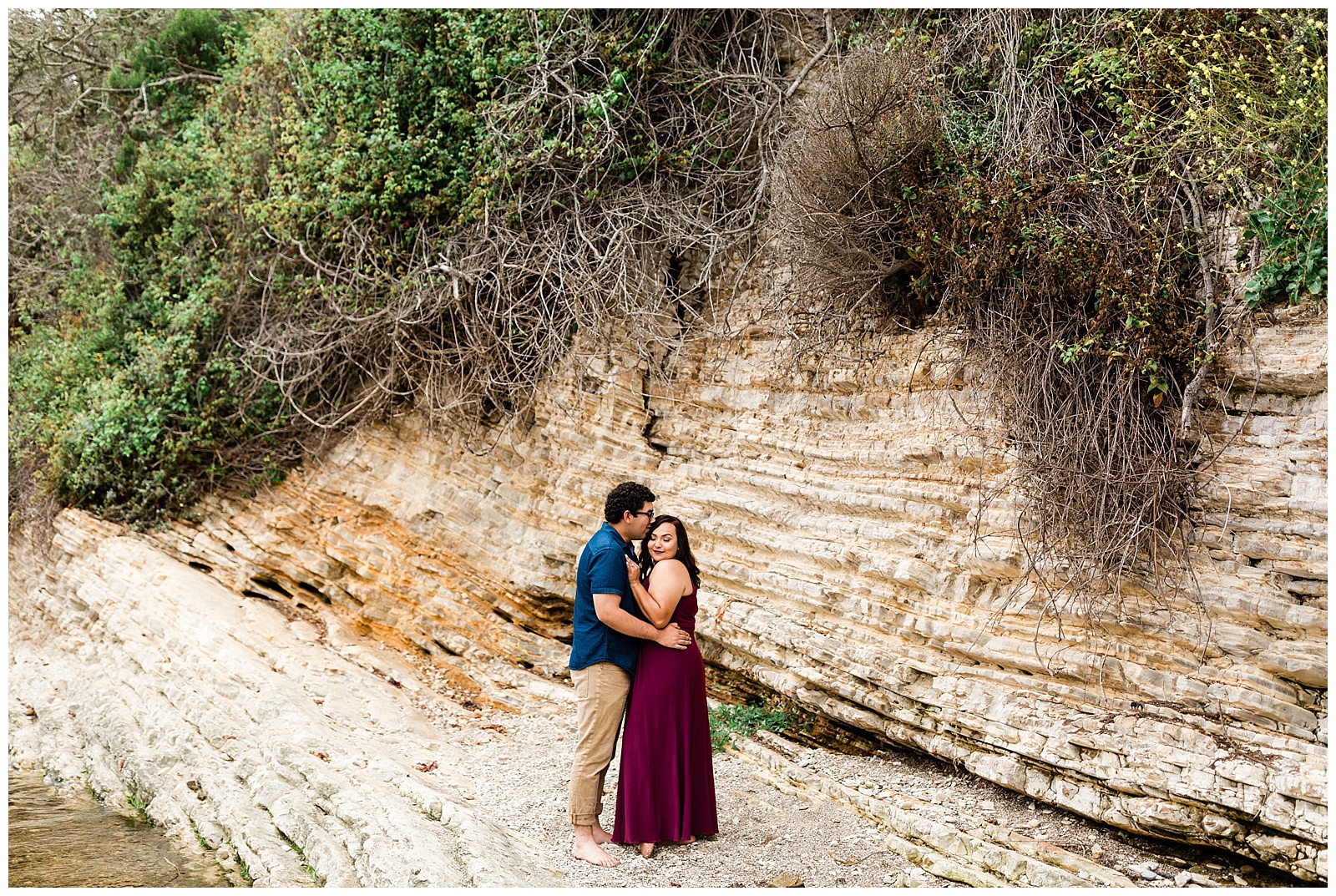 couple embracing while he kisses her forehead for a foggy coastal engagement session with fresno wedding photographer megan helm