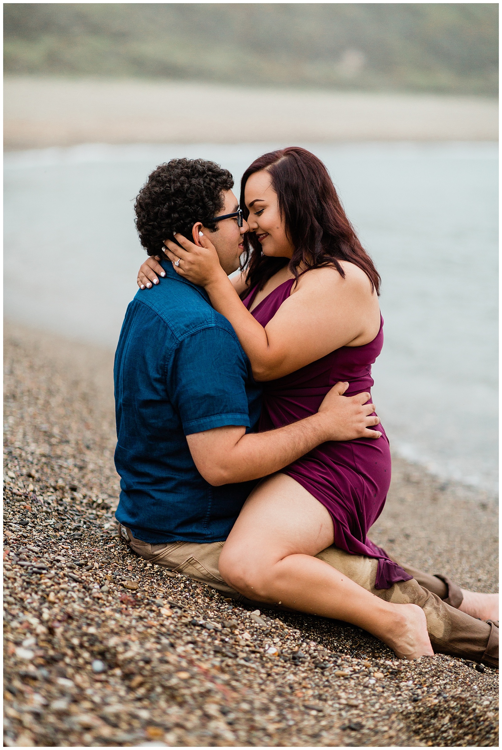foggy coastal engagement photos of a couple cuddling on the beach