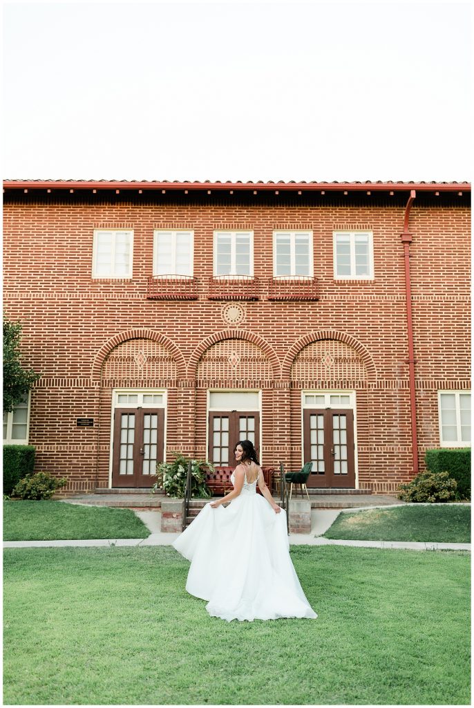 bride walking along the grass with a flowing skirt by made with love bridal