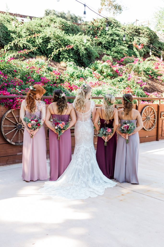 back of bride and bridesmaids with florals