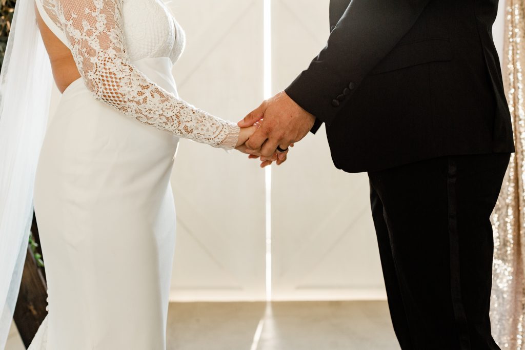 couple holding hands during their wedding ceremony