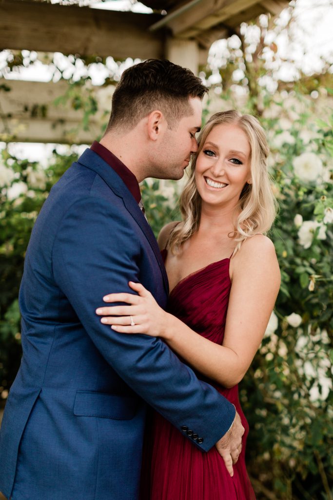 man nuzzling into his fiances cheek as she smiles after their surprise proposal