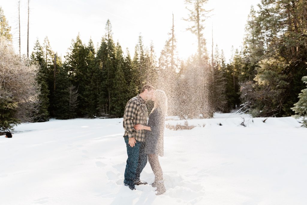 snow falling after a throw while couple is kissing