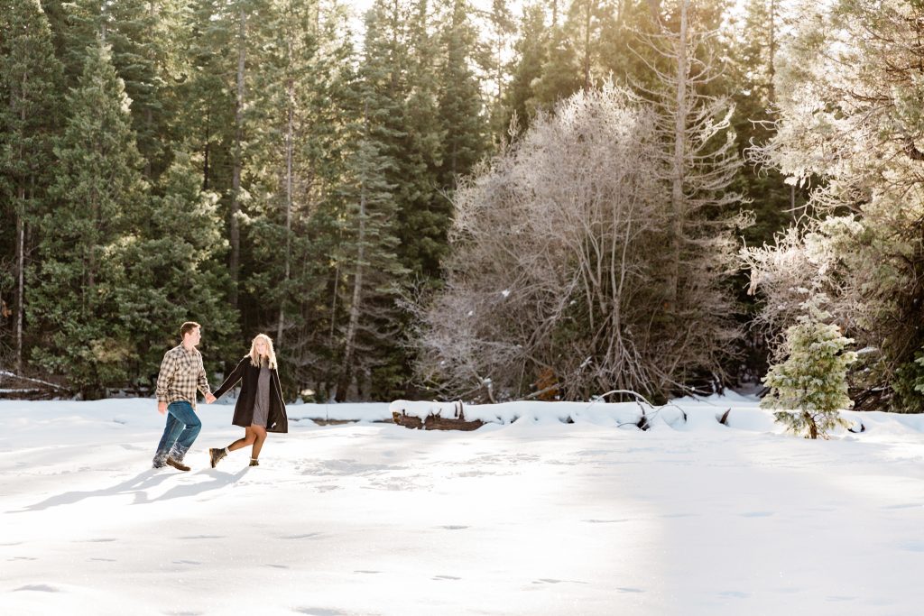 couple running through the snow in Shaver Lake