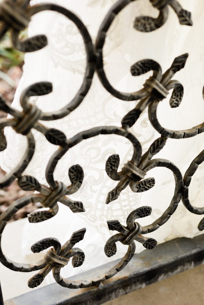 detailed wrought iron fence at Wolf Lakes Park with wedding dress lace
