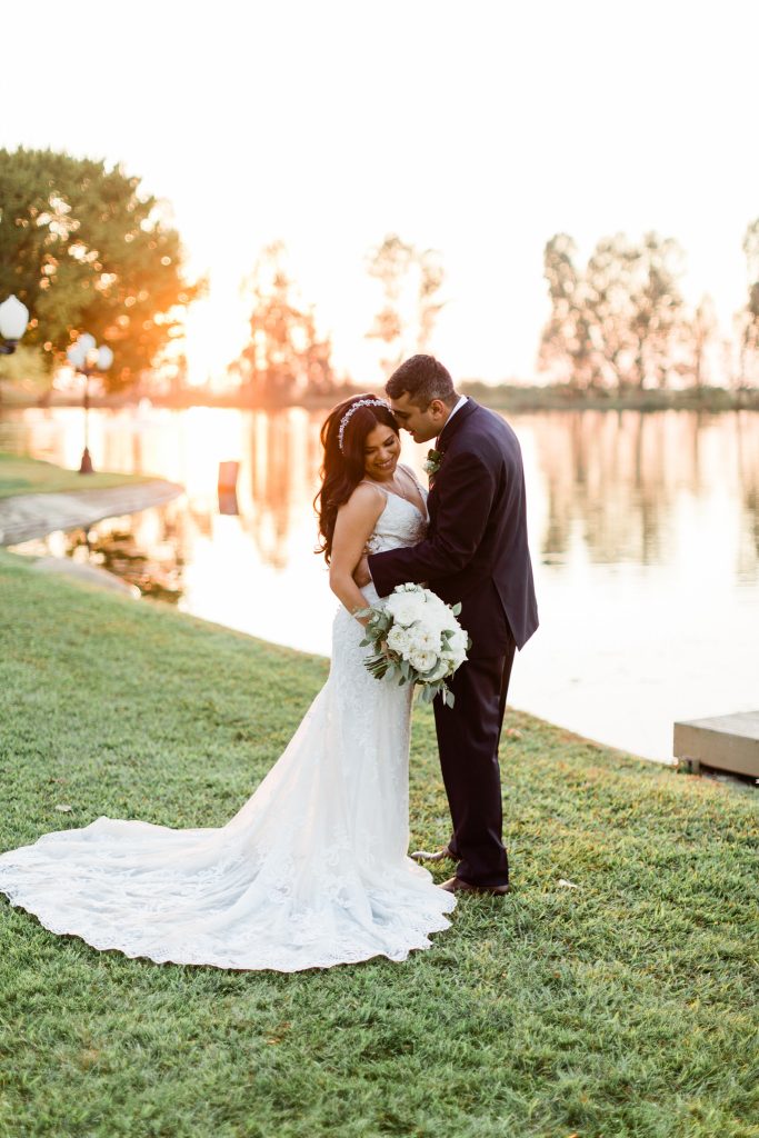 groom snuggled up to bride at sunset in front of Wolf Lakes Park