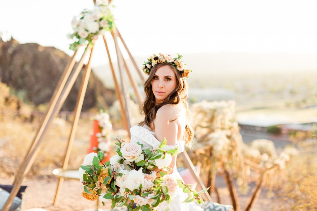 elopement photo of woman in desert with bohemian decor and flowers