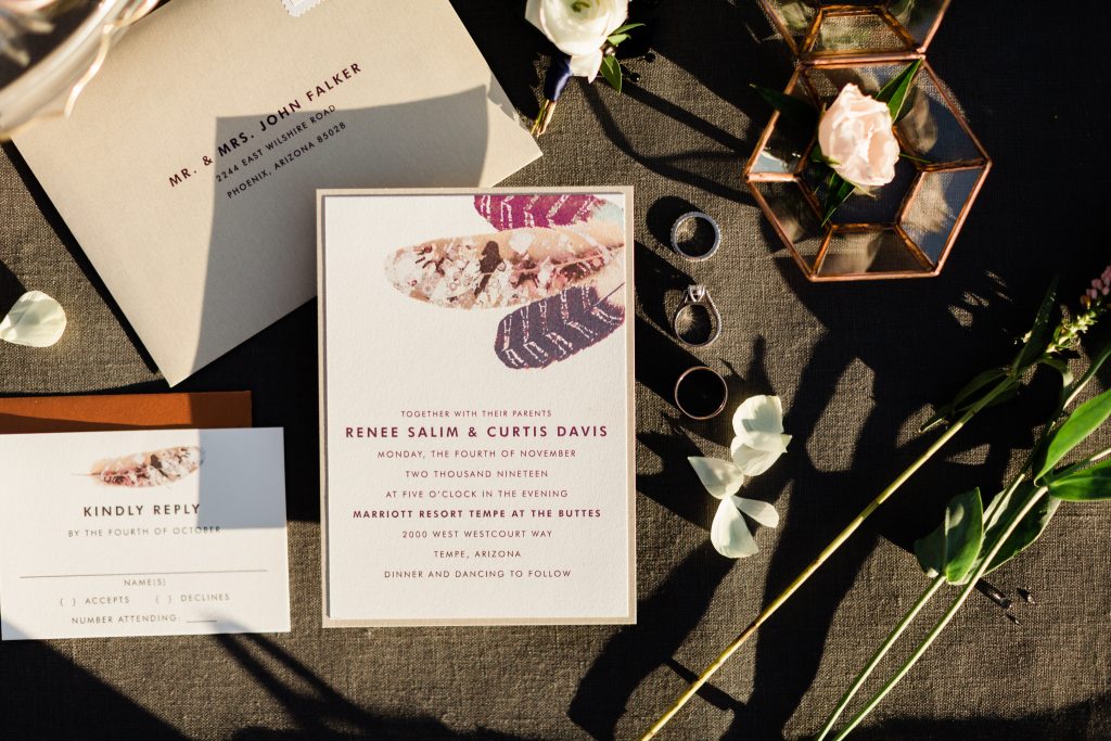 elopement wedding invitations on a grey linen background with the sun casting shadows