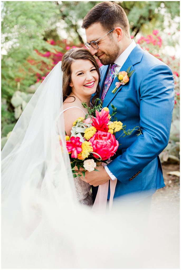 bride and groom with colorful florals
